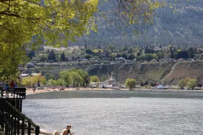 a person walking a dog next to a body of water at Grandma's Elephant Hideaway in Penticton