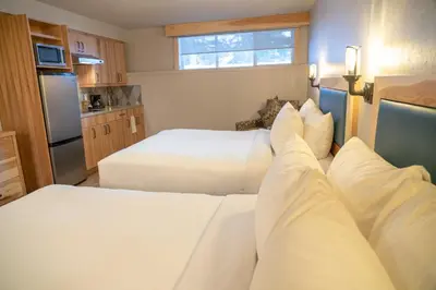 a hotel room with two beds and a kitchen at Tunnel Mountain Resort in Banff