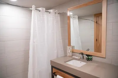 a bathroom with a white shower curtain and a sink at Tunnel Mountain Resort in Banff