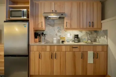 a kitchen with wooden cabinets and a stainless steel refrigerator at Tunnel Mountain Resort in Banff