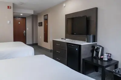 a hotel room with two beds and a flat screen tv at Red Carpet Inn in Banff
