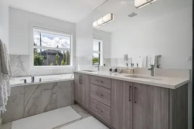 a bathroom with a sink and a tub and a window at Luxury Spacious Private House near City Centre in Calgary