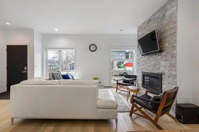 a living room with a white couch and a fireplace at Luxury Spacious Private House near City Centre in Calgary