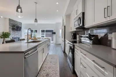 a large kitchen with white cabinets and a counter top at Contemporary Luxury 4 bedroom House near Downtown in Calgary