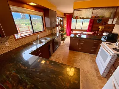 a large kitchen with a sink and a stove at The Country Barn in Port Alberni