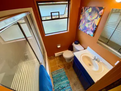 a bathroom with a sink and a toilet and a window at The Country Barn in Port Alberni