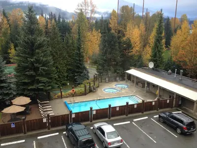 a pool at a resort with cars parked in a parking lot at Tantalus Resort Lodge in Whistler
