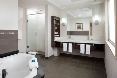 a bathroom with a tub and two sinks and a bath tub at Delta Hotels by Marriott Calgary South in Calgary
