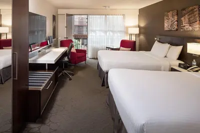 a hotel room with two beds and a desk at Delta Hotels by Marriott Calgary South in Calgary