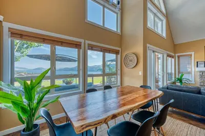 a dining room with a wooden table and chairs at Exceptional Boutique Cottage with Incredible Lake View in Kelowna