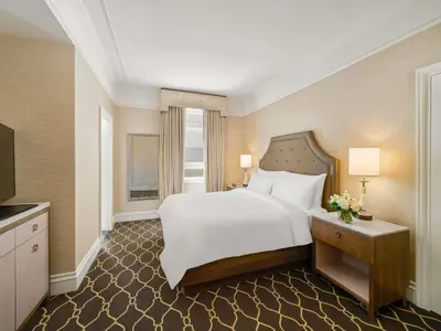 a bedroom with a large white bed and a window at Fairmont Palliser in Calgary