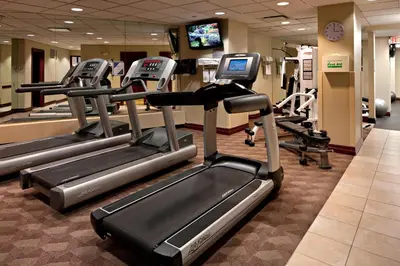 a gym with several tread machines in a room at Delta Hotels Calgary Airport In-Terminal in Calgary