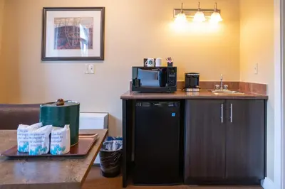 a hotel room with a sink and a microwave at Irwin's Mountain Inn in Banff