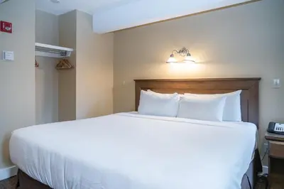 a bedroom with a large white bed in a hotel room at Irwin's Mountain Inn in Banff