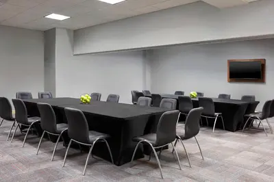 a conference room with a black table and chairs at Aloft Hotel Calgary University in Calgary