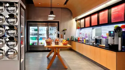 a restaurant with a table in front of a counter at Aloft Hotel Calgary University in Calgary