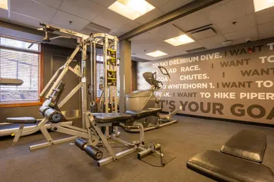 a gym with a weight room with a bench and equipment at Blackstone Mountain Lodge by CLIQUE in Canmore