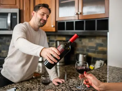 a man pouring a glass of wine in a kitchen at Blackstone Mountain Lodge by CLIQUE in Canmore