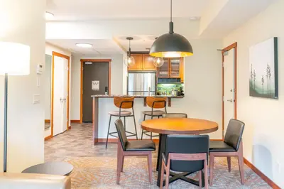a dining room and kitchen with a table and chairs at Blackstone Mountain Lodge by CLIQUE in Canmore