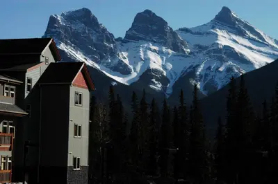 a view of a snow covered mountain with a building at Lodges at Canmore in Canmore
