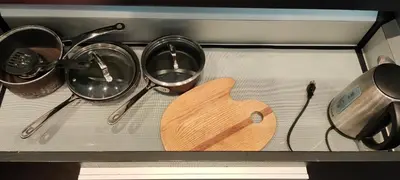a stove with pots and pans and a cutting board at WaterFalls Hotel - Suite in Falls Downtown with pool in Victoria