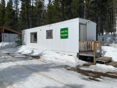 a white building with a sign on it in the snow at Jade City Bungalow in Jade City