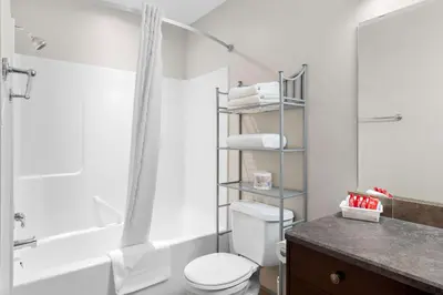 a bathroom with a toilet and a shower and a sink at SureStay Plus Hotel by Best Western Hardisty in Hardisty
