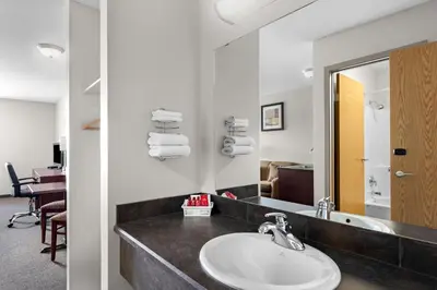 a bathroom with a sink and a mirror at SureStay Plus Hotel by Best Western Hardisty in Hardisty