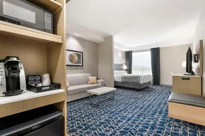 a hotel room with a bed and a living room at Best Western Premier Route 97 Vernon in Vernon