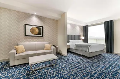 a hotel room with a bed and a couch at Best Western Premier Route 97 Vernon in Vernon