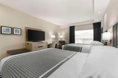 a hotel room with two beds and a flat screen tv at Best Western Premier Route 97 Vernon in Vernon