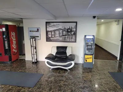 a waiting room with a chair next to a machine at Super 8 North Red Deer in Red Deer
