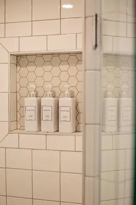four bottles ofodorizers sit on a shelf in a bathroom at Stirling All Suites Hotel in Nelson