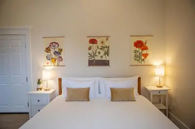 a bedroom with a large white bed with two lamps at Stirling All Suites Hotel in Nelson