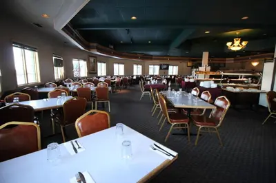 a dining room with tables and chairs in a restaurant at Travelodge by Wyndham Lacombe in Lacombe