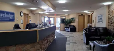 a lobby of a waiting room with chairs and a counter at Travelodge by Wyndham Lacombe in Lacombe