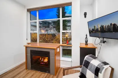 a living room with a fireplace and a tv at Luxury and Modern Studio at Blackcomb base in Whistler