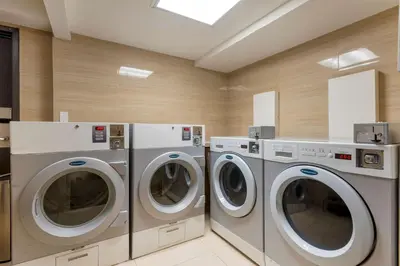 a laundry room with two washers and two dryers at Best Western Plus Village Park Inn in Calgary