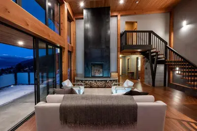 a living room with a couch and a fireplace at Luxe Modern Timberframe - Iconic Panorama Views with AC in Nelson