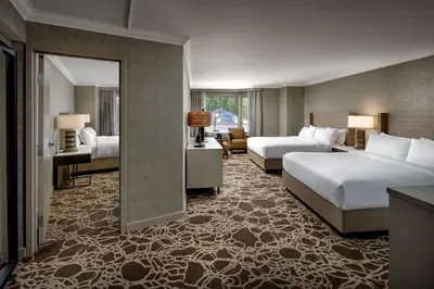 a hotel room with two beds and a mirror at Kananaskis Mountain Lodge, Autograph Collection in Kananaskis Village