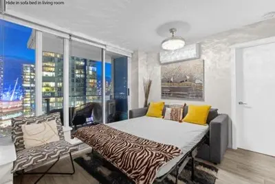 a bedroom with a bed and a couch and a window at Beautiful Bright with water view AC DT 2BR 2BTh 3BD sleeps 6 guests in Vancouver