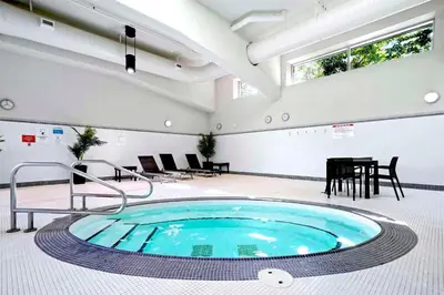 a large pool in a room with a table and chairs at Beautiful Bright with water view AC DT 2BR 2BTh 3BD sleeps 6 guests in Vancouver