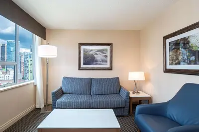 a living room with a couch and a chair at Best Western Premier Chateau Granville Hotel & Suites & Conference Centre in Vancouver