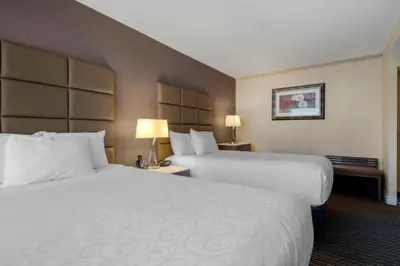 a hotel room with two beds and two lamps at Best Western Premier Chateau Granville Hotel & Suites & Conference Centre in Vancouver