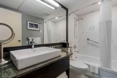 a bathroom with a sink and a shower and a toilet at Best Western Premier Chateau Granville Hotel & Suites & Conference Centre in Vancouver