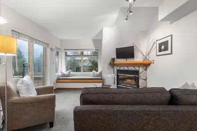 a living room with a couch and a fireplace at 1BR in Lake Placid Lodge, Steps to Creekside Gondola, Shared Pool and Hot Tub, Lounge Access in Whistler