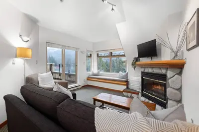a living room with a couch and a fireplace at 1BR in Lake Placid Lodge, Steps to Creekside Gondola, Shared Pool and Hot Tub, Lounge Access in Whistler