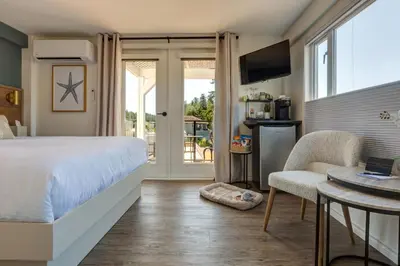 a bedroom with a bed and a table with a chair at Manana Resort and Marina in Ladysmith