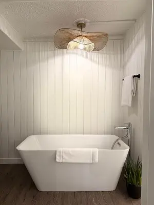 a white bath tub in a bathroom with a ceiling fan at Manana Resort and Marina in Ladysmith