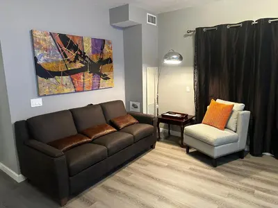 a living room with a couch and a chair at Luxury Two Queen Beds Condo - Grande Rockies Resort Indoor Parking Pool Hot tub GYM in Canmore